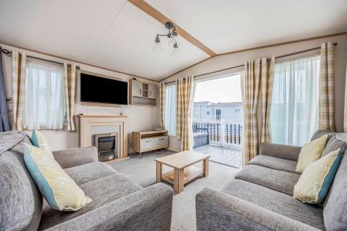 a living room with two couches and a television at Charming Home in Lakeside Park - Pass The Keys in Chichester