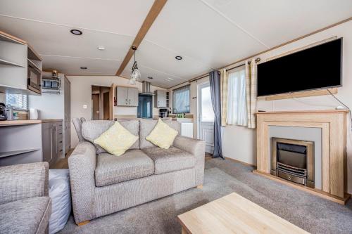 a living room with a couch and a fireplace at Charming Home in Lakeside Park - Pass The Keys in Chichester