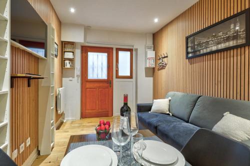 un salon avec un canapé bleu et une table dans l'établissement TBS 329 - Charming studio in Paris, à Paris