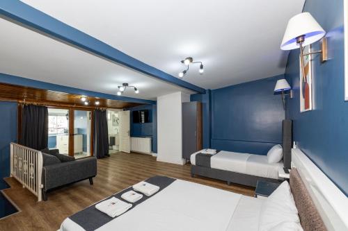a bedroom with blue walls and a bed and a couch at Taxim Trend Suites in Istanbul