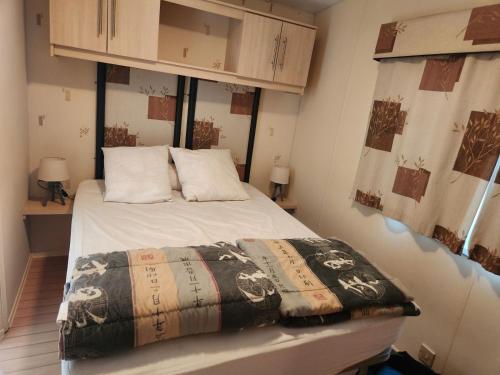 une chambre avec un lit avec une couverture dessus dans l'établissement MOBIL-HOME 6 pers, 40 M2, 2 CH, 2 SDB, à Saint-Augustin
