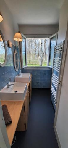 La salle de bains est pourvue de 2 lavabos et d'une grande fenêtre. dans l'établissement Gîte près de Sarlat avec jardin et salon de massages, à Carsac-Aillac