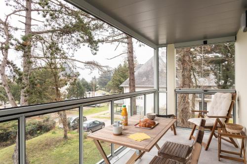 une pièce avec une table et des chaises sur un balcon dans l'établissement Les pins #208 - 6min à pied de la plage, à Fréhel