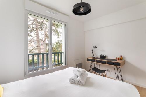 una camera da letto bianca con un letto e una finestra di Les pins #208 - 6min à pied de la plage a Fréhel