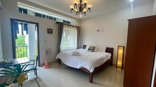 a bedroom with a white bed and a window at Rocky Cafe & Mini Apartment in Siem Reap