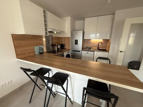 une cuisine avec un comptoir en bois et des chaises dans l'établissement Bellevue, à Annecy