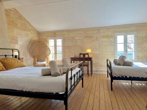 une chambre avec deux lits dans une pièce dans l'établissement Charmante maison en pierre, proche de St Émilion, à Montagne