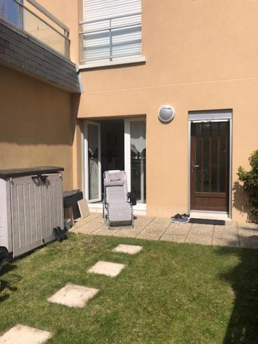 une chaise de jardin assise dans une cour à côté d'une maison dans l'établissement Les pieds dans l'eau, à Saint-Malo