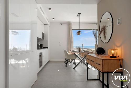 een keuken en eetkamer met een tafel en een spiegel bij VIVI Homes - Bonita del Sol Beach, Pool, Garden, GYM & SPA in La Cala de Mijas