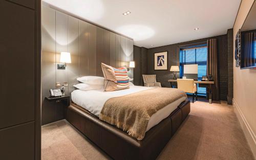 a bedroom with a large bed with a large headboard at Dakota Eurocentral in Motherwell