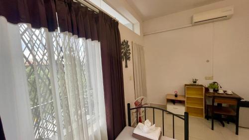 a bedroom with a window with curtains and a desk at Rocky Cafe & Mini Apartment in Siem Reap