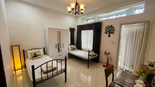 a bedroom with two beds and a chandelier at Rocky Cafe & Mini Apartment in Siem Reap