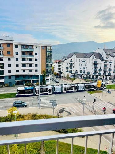 a city with buildings and a street with a bus at LE GOLDEN accès direct tramway Genève avec parking in Ambilly