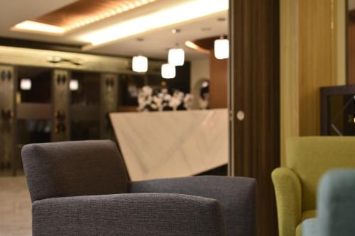a room with two chairs and a table and a mirror at 衿后禾居民生館 Good Hotel Minsheng in Kaohsiung
