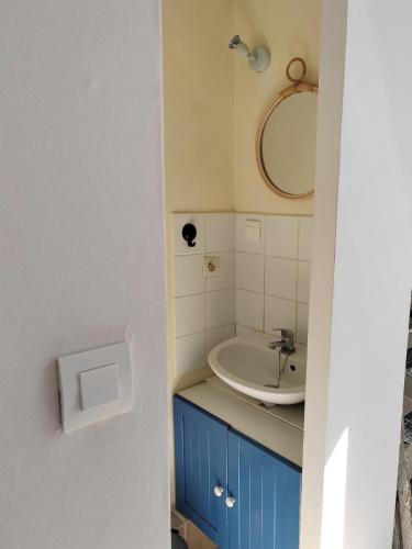 une salle de bain avec un lavabo et un miroir dans l'établissement La Golondrina, à Villefranche-sur-Saône