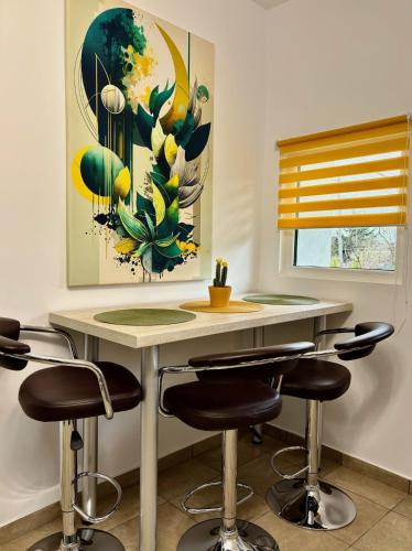 a kitchen with a table with chairs and a painting at Casa SOFI Nr 1, Breaza PH in Breaza