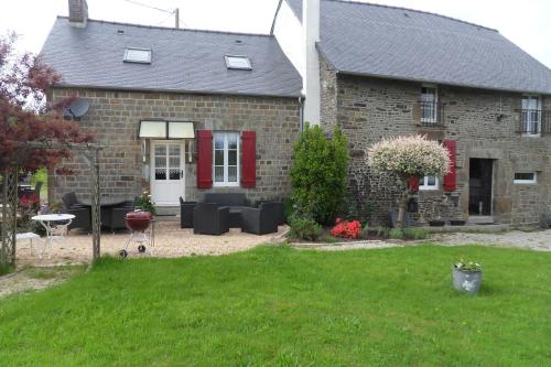 a brick house with a red door and a yard at Chambres et table d'hôtes du Vieil Hêtre in Mantilly