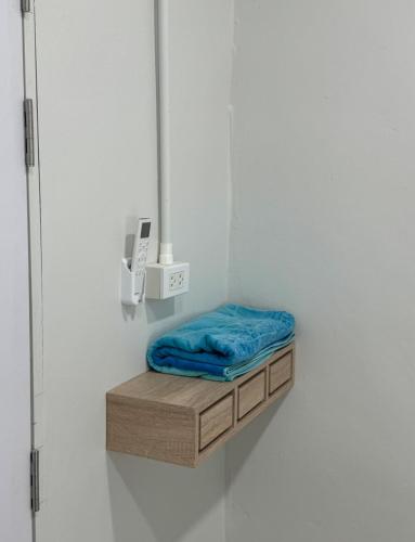 a small shelf with a blue pillow on a wall at The Little House in Chaloklum