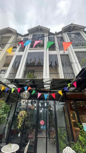 a building with colorful flags in front of it at Rocky Cafe & Mini Apartment in Siem Reap