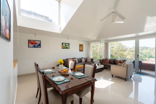 a living room with a table and a couch at El Sereno 2 BHK Stylish Apartments In Vagator with Garden and Pool- 10 minutes drive to Vagator Beach in Chapora