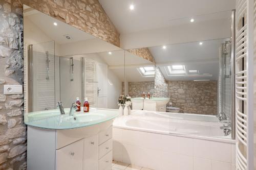 La salle de bains est pourvue d'une grande baignoire et d'un lavabo. dans l'établissement Maison 8 personnes a 15 mn de bergerac, à Gageac-et-Rouillac