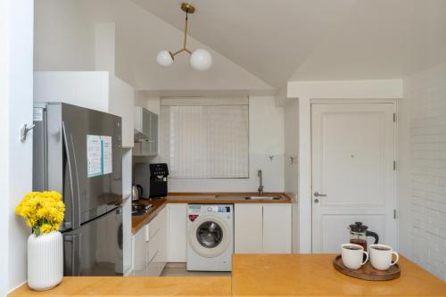 a kitchen with a refrigerator and a washing machine at El Sereno 2 BHK Stylish Apartments In Vagator with Garden and Pool- 10 minutes drive to Vagator Beach in Chapora