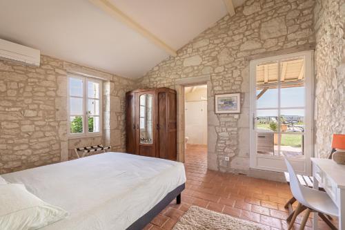 une chambre avec un lit et un mur en pierre dans l'établissement Maison 8 personnes a 15 mn de bergerac, à Gageac-et-Rouillac
