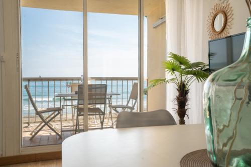 a living room with a table and a view of the ocean at Les Pieds dans l'eau YourHostHelper in Palavas-les-Flots
