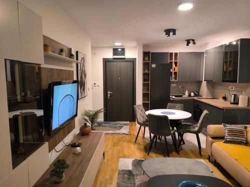 a living room with a couch and a table with a tv at COMODO "Green Hill" in Soko Banja