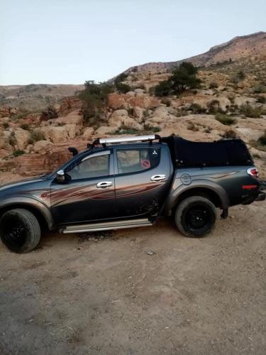 a car parked on the side of a dirt road at Dana to Petra Hiking Camping in Dana