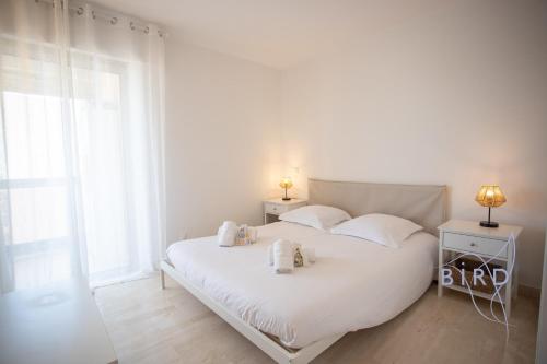 une chambre avec un lit blanc avec deux serviettes dessus dans l'établissement Bright pied-à-terre WilsonAntibes, à Antibes