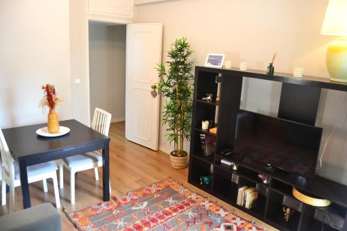 a living room with a television and a dining room table at JAM Retreat in Lisbon
