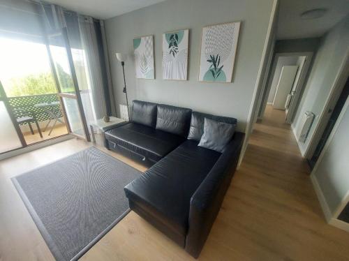 a living room with a black couch and a balcony at EL RINCON DE AJO two people or less only one room available in Ajo