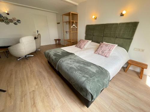 a bedroom with a bed and a desk and a chair at Bed and Breakfast de Salix in Hitzum