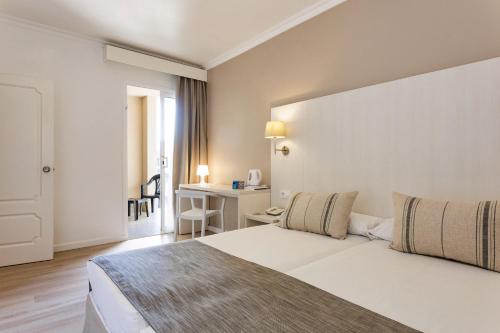 a hotel room with a bed and a desk at Minura Sur Menorca in Punta Prima