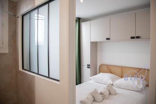 une chambre avec un lit avec des oreillers blancs et une fenêtre dans l'établissement A haven of peace in the city center, à Cannes