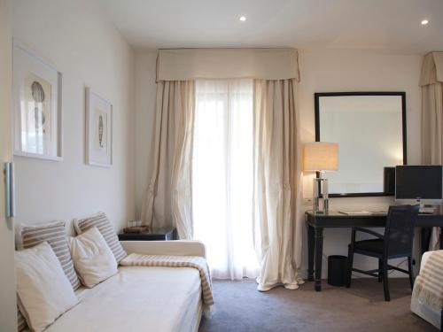 a living room with a couch and a desk with a computer at California Park Hotel in Forte dei Marmi