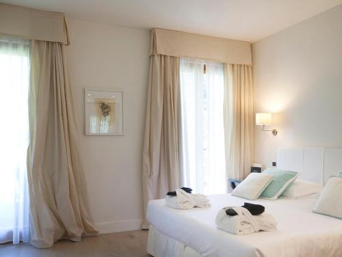 two beds in a hotel room with towels on them at California Park Hotel in Forte dei Marmi