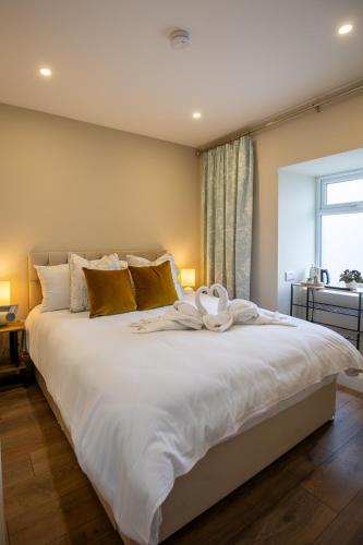 a large white bed in a room with a window at The Oyster House in Clarinbridge