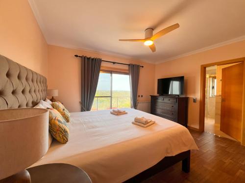 a bedroom with a large bed with a ceiling fan at Luxuosa Vila Alvorninha in Alvorninha