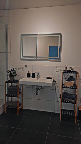 a bathroom with a sink and a mirror and a chair at Vineyard-Suites Traumferienwohnung mit Panoramablick und Weinidylle in Elsenfeld