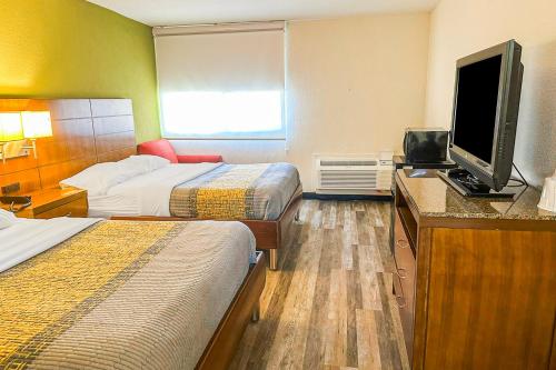 a hotel room with two beds and a flat screen tv at Jackson Hotel And Convention Center in Jackson