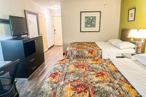 a hotel room with two beds and a flat screen tv at Jackson Hotel And Convention Center in Jackson