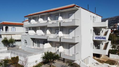 a white building with a sign on it at Ξενοδοχείο Βεργίνα in Oikonomiánika