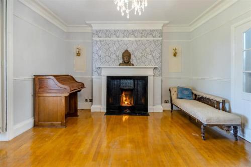 a living room with a piano and a fireplace at The Manor Shifnal Telford in Shifnal