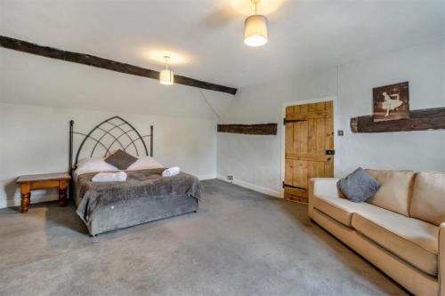 a living room with a bed and a couch at The Manor Shifnal Telford in Shifnal