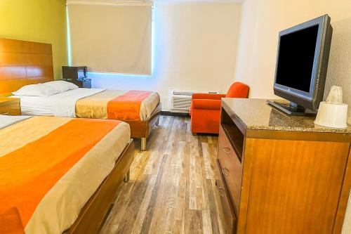 a hotel room with two beds and a flat screen tv at Jackson Hotel And Convention Center in Jackson