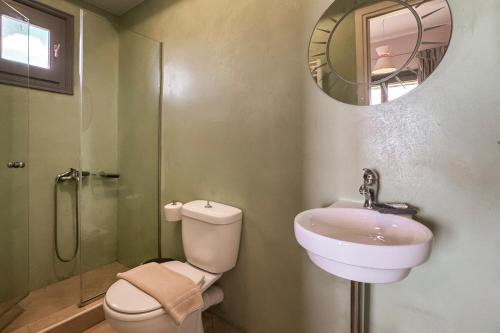a bathroom with a sink and a toilet and a mirror at YaChara Villa in Kissamos
