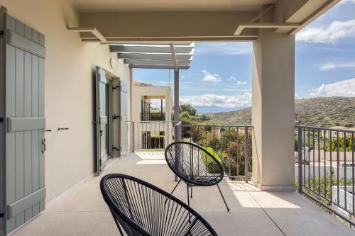 a balcony with two chairs and a view at YaChara Villa in Kissamos