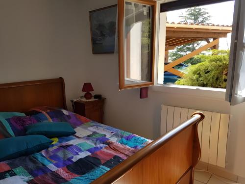 a bedroom with a bed and a window at Chez Louis in Revel-Tourdan